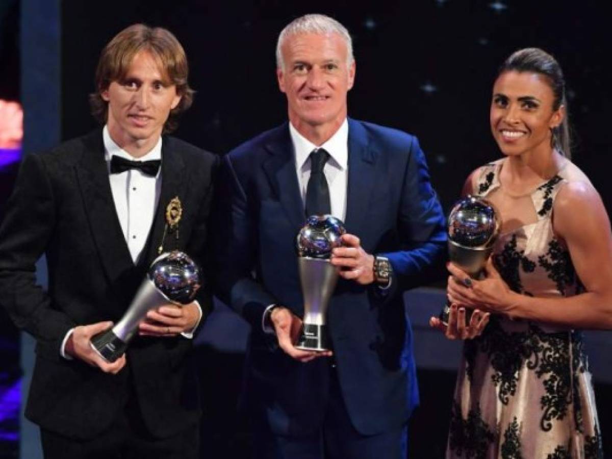 France's coach Didier Deschamps (C), winner of the Best FIFA Men's Coach of 2018 Award, is flanked by Orlando Pride and Brazil forward Marta (R) and Real Madrid and Croatia midfielder Luka Modric (L) winners of the Best FIFA Women's and Men's Player of 2018 Award, as they pose for a photograph with their trophies during The Best FIFA Football Awards ceremony, on September 24, 2018 in London. / AFP PHOTO / Ben STANSALL