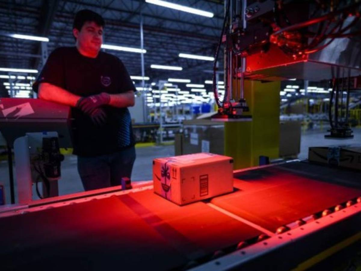 A man monitors the addressing process at the 855,000-square-foot Amazon fulfillment center in Staten Island, one of the five boroughs of New York City, on February 5, 2019. - Inside a huge warehouse on Staten Island thousands of robots are busy distributing thousands of items sold by the giant of online sales, Amazon. (Photo by Johannes EISELE / AFP)