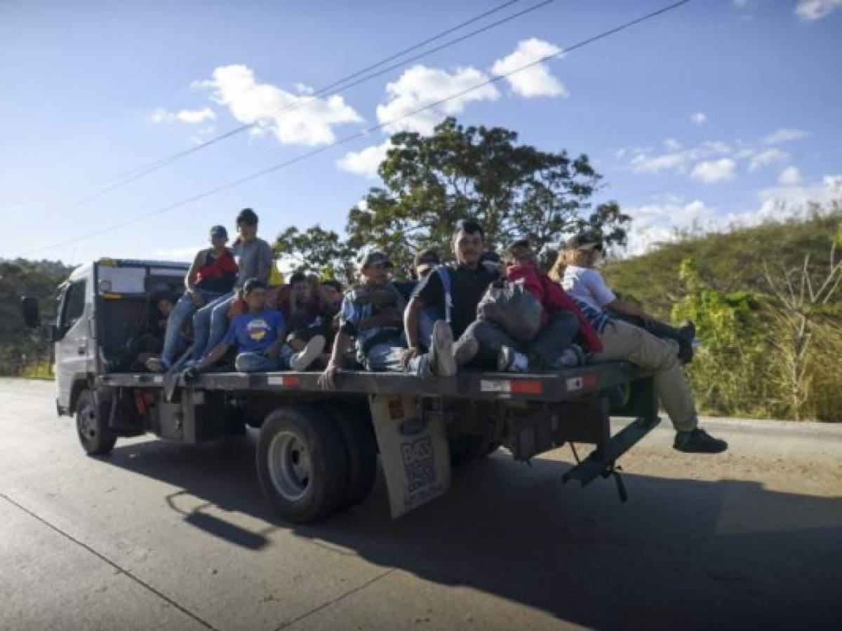 Honduran migrants travel on the back of a truck in Zacapa departament, Guatemala, on January 17, 2020, on their way to the US. - Mexican President Andres Manuel Lopez Obrador offered 4,000 jobs Friday to migrants in a new caravan currently crossing Central America toward the United States. The caravan, which formed in Honduras this week and is making its way across Guatemala, currently has around 3,000 migrants, Lopez Obrador said. (Photo by Johan ORDONEZ / AFP)