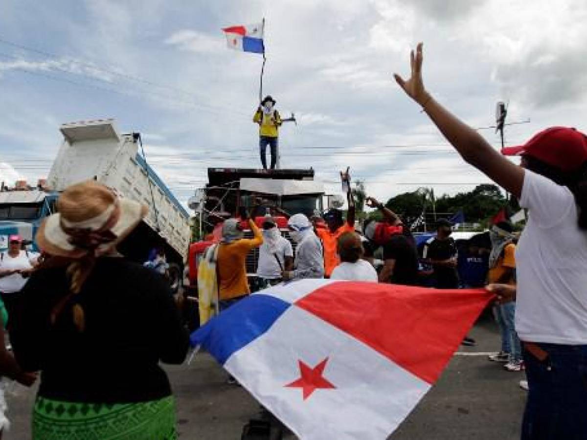 Un hombre ondea una bandera panameña encima de un camión mientras la carretera Panamericana permanece bloqueada en Chame, Panamá, el 14 de julio de 2022. (Foto de ROGELIO FIGUEROA / AFP)