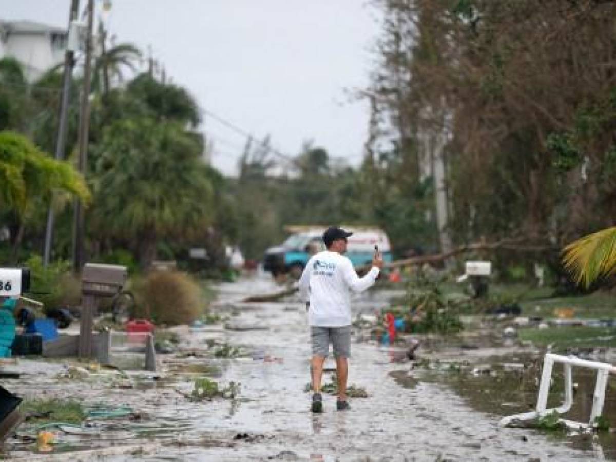 BONITA SPRINGS, FL - 29 DE SEPTIEMBRE: Un hombre documenta los daños causados por la tormenta con su teléfono después del huracán Ian el 29 de septiembre de 2022 en Bonita Springs, Florida. La tormenta tocó tierra en los EE. UU. en Cayo Costa, Florida, y trajo fuertes vientos, marejadas ciclónicas y lluvia al área causando daños severos. Sean Rayford/Getty Images/AFP (Foto de Sean Rayford/GETTY IMAGES NORTH AMERICA/Getty Images vía AFP)