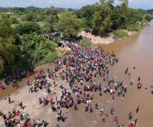 Aerial view showing migrants reaching Mexico after crossing the Suchiate River from Tecun Uman in Guatemala to Ciudad Hidalgo in Mexico on October 29, 2018, a day after a security fence on the international bridge was reinforced to prevent them from passing through. - Thousands of Honduran migrants in different groups are attempting to join a larger caravan of compatriots heading towards the United States. (Photo by Carlos ALONZO / AFP)