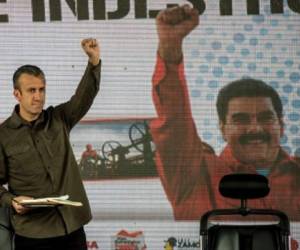 Venezuelan President Nicolas Maduro (not framed) and his vice-president Tareck El Aissami (L) participate in a rally with workers of PDVSA state-owned oil company in Carcas January 31, 2017. Maduro broadened the powers of his hardline number two in a decree Tuesday that analysts said showed he may be grooming him to take over as president. / AFP PHOTO / JUAN BARRETO