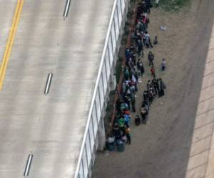 Migrantes que piden asilo esperan afuera de la frontera de Estados Unidos - México. John Moore/Getty Images/AFP