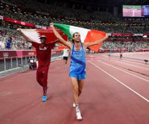 Gold medalist Mutaz Essa Barshim (L) of Team Qatar and silver medalist Gianmarco Tamberi of Team Italy celebrate on the track following the Men's High Jump Final during the Tokyo 2020 Olympic Games at the Olympic Stadium in Tokyo on August 1, 2021. (Photo by Christian Petersen / POOL / AFP)