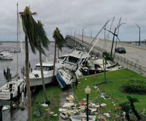FORT MYERS FLORIDA - 29 DE SEPTIEMBRE: Los barcos son empujados hacia arriba en una calzada después de que el huracán Ian pasara por el área el 29 de septiembre de 2022 en Fort Myers, Florida. El huracán trajo fuertes vientos, marejadas ciclónicas y lluvias al área causando daños severos. Joe Raedle/Getty Images/AFP (Foto de JOE RAEDLE/GETTY IMAGES NORTH AMERICA/Getty Images vía AFP)