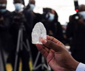 A Botswana member of cabinet holds a gem diamond in Gaborone, Botswana, on June 16, 2021. - Botswanan diamond firm Debswana said on June 16, 2021 it had unearthed a 1,098-carat stone that it described as the third largest of its kind in the world.The stone, found on June 1, 2021 was shown to President Mokgweetsi Masisi in the capital Gaborone. (Photo by Monirul Bhuiyan / AFP)