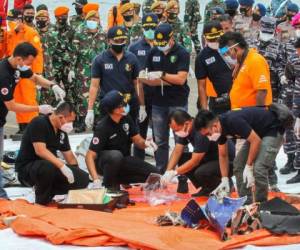 Los equipos de rescate inspeccionan los artículos recuperados y los escombros en el puerto de Yakarta el 10 de enero de 2021, durante la operación de búsqueda del vuelo SJY182 de Sriwijaya Air, que se estrelló después de despegar de Yakarta el 9 de enero (Foto de Dany Krisnadhi / AFP).