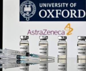 Una imagen ilustrada muestra viales con adhesivos de vacuna Covid-19 adheridos y jeringas, con el logotipo de la Universidad de Oxford y su empresa farmacéutica británica asociada AstraZeneca, el 17 de noviembre de 2020 (Foto de JUSTIN TALLIS / AFP).