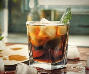 Glass of rum on the wooden background, Cuba Libre or long island iced tea cocktail with strong drinks, cola,