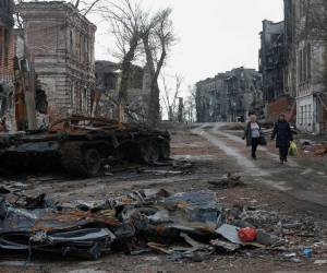 Gente camina en los restos de edificios en Mariupol, Ucrania el 22 de abril, 2022. REUTERS/Alexander Ermochenko