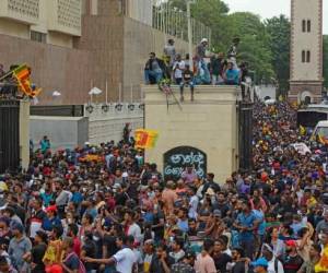 Manifestantes que exigen la renuncia del presidente de Sri Lanka, Gotabaya Rajapaksa, se reúnen dentro del complejo del Palacio Presidencial de Sri Lanka en Colombo el 9 de julio de 2022. - El asediado presidente de Sri Lanka, Gotabaya Rajapaksa, huyó de su residencia oficial en Colombo, dijo a la AFP una importante fuente de defensa, ante los manifestantes reunidos para exigir su dimisión irrumpieron en el recinto. (Foto por AFP)