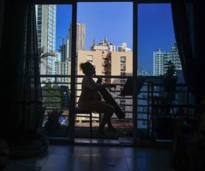 Uruguayan cellist Karina Nunez plays on the balcony of her apartment in Panama City on March 23, 2020, during mandatory isolation due to the new coronavirus pandemic. (Photo by Luis ACOSTA / AFP)