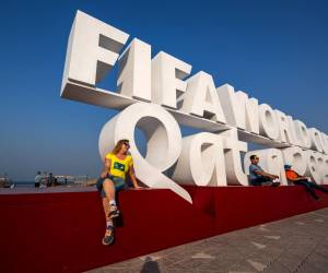 Visitors pose for photos with a FIFA World Cup sign in Doha on October 25, 2022, ahead of the Qatar 2022 FIFA World Cup football tournament. (Photo by Jewel SAMAD / AFP)