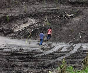 ARCHIVO: Dos jovenes caminan en medio de un area deforestada por el Ministerio de Obras Publicas para la construccion de una autopista que atraviesa la reserva ecologica 'Finca El Espino', en San Salvador. AFP PHOTO/ Yuri CORTEZ (Photo by YURI CORTEZ / AFP)