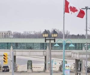 A car stops at a Canadian Customs booth in Niagara Falls, Ontario, on March 18, 2020, hours after Prime Minister Justin Trudeau announced the closing of the border with the US to all tourists. - US and Canada have mutually agreed on March 18, 2020 to temporarily restrict ' non essential traffic' accross Canada-US border due to the coronavirus pandemic. (Photo by Geoff Robins / AFP)