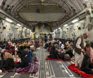 Afghan people sit inside a U S military aircraft to leave Afghanistan, at the military airport in Kabul on August 19, 2021 after Taliban's military takeover of Afghanistan. (Photo by Shakib RAHMANI / AFP)