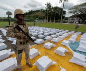 (FILES) In this file photo taken on October 30, 2021 members of the National Aeronaval Service (SENAN) guard drug packages as they are displayed during a press conference at a military base in Panama City. - Central American countries seized around 250 tons of drug in 2021, a record figure originated by the increase in the production of cocaine and the new strategies of drug traffickers to transport it to the US and Europe. (Photo by Rogelio FIGUEROA / AFP)