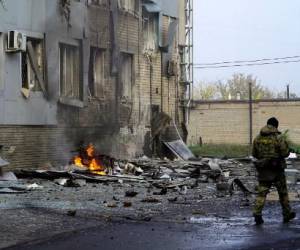 Un militar protege el sitio de la explosión de un coche bomba frente a un edificio que alberga una estación de televisión local en la ciudad rusa de Melitopol, en el sur de Ucrania, el 25 de octubre de 2022. FOTO STRINGER / AFP