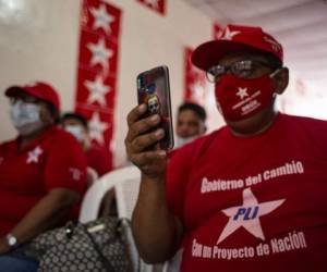 A supporter of Nicaragua's Liberal Independent Party (PLI) presidential candidate Mauricio Orue Vazquez takes a snapshot with his mobile phone during the final campaign rally in Managua, on November 1, 2021. - Nicaragua will hold general election next November 7. (Photo by Oswaldo Rivas / AFP)