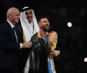<i>El delantero argentino #10 Lionel Messi sostiene el trofeo de la Copa del Mundo después de recibirlo del presidente de la FIFA Gianni Infantino y el emir Sheikh Tamim bin Hamad al-Thani de Qatar durante la ceremonia del trofeo de la Copa del Mundo de Qatar 2022 después del partido final de fútbol entre Argentina y Francia en el Estadio Lusail en Lusail, al norte de Doha el 18 de diciembre de 2022. - Argentina ganó en la tanda de penaltis. (Foto de FRANCK FIFE / AFP)</i>