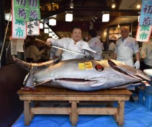 Kiyoshi Kimura (C), president of Kiyomura Corp., the Tokyo-based operator of sushi restaurant chain Sushizanmai, poses with a sword before slicing up a bluefin tuna the company bought for 193.2 million yen (1.8 million USD) at auction at his main restaurant in Tokyo on January 5, 2020. - Kiyomura Corp. made the winning bid of 1.8 million USD for a 276-kilogram bluefin tuna caught off Oma, Aomori prefecture at the first auction of the year earlier in the day at Tososu fish market. (Photo by Kazuhiro NOGI / AFP)