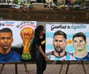 Students adjust paintings of Argentina's forward Lionel Messi and France's forward Kylian Mbappé ahead of the Qatar 2022 FIFA World Cup football final match between France and Argentina, at an art school in Mumbai on December 16, 2022. (Photo by Punit PARANJPE / AFP)