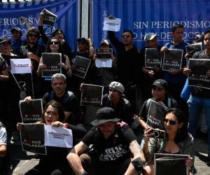 <i>Periodistas y miembros de la Sociedad Civil guatemalteca sostienen pancartas con el hashtag #NoNosSilenciarán, durante un plantón contra la amenaza a la libertad de expresión y la persecución penal de comunicadores, frente a un juzgado de Ciudad de Guatemala el 4 de marzo de 2023. FOTO JOHAN ORDONEZ / AFP</i>