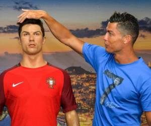 Portugese forward Cristiano Ronaldo poses next to a wax statue representing himself during a visit to the new location of the CR7 museum dedicated his professional career at Funchal, on the Portuguese island of Madeira on July 23, 2016. (Photo by JOANA SOUSA / AFP)