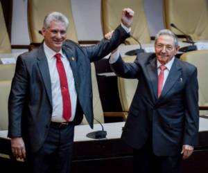 Outgoing Cuban President Raul Castro (R) raises the arm of Cuba's new President Miguel Diaz-Canel after he was formally named by the National Assembly, in Havana on April 19, 2018. Miguel Diaz-Canel succeeds Raul Castro -- a historic handover ending six decades of rule by the Castro brothers. The 57-year-old Diaz-Canel, who was the only candidate for the presidency, was elected to a five-year term with 603 out of 604 possible votes in the National Assembly. / AFP PHOTO / Adalberto ROQUE