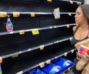 Una mujer mira estantes vacíos de gel antibacterial en un supermercado en Ciudad de Panamá el 11 de marzo de 2020. (Foto Luis ACOSTA / AFP)