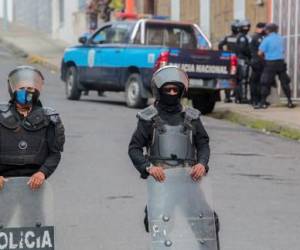(ARCHIVOS) En esta foto de archivo tomada el 04 de agosto de 2022, policías y antidisturbios bloquean la entrada principal de la Curia Arzobispal de Matagalpa impidiendo la salida de Monseñor Rolando Álvarez, en Matagalpa, Nicaragua. - El obispo nicaragüense Rolando Álvarez, crítico con el gobierno de Daniel Ortega, fue sacado “violentamente” de su residencia en Matagalpa (norte), donde estuvo retenido por policías durante dos semanas, y se desconoce su paradero, dijo en agosto una organización de derechos humanos. 19 de febrero de 2022. (Foto de AFP)