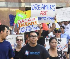 Young immigrants and supporters walk holding signs during a rally in support of Deferred Action for Childhood Arrivals (DACA) in Los Angeles, California on September 1, 2017.A decision is expected in coming days on whether US President Trump will end the program by his predecessor, former President Obama, on DACA which has protected some 800,000 undocumented immigrants, also known as Dreamers, since 2012. / AFP PHOTO / FREDERIC J. BROWN