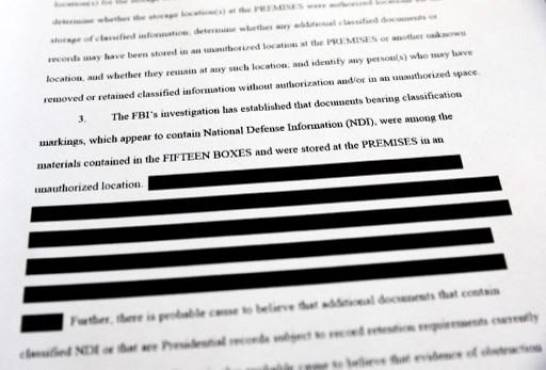 CALIFORNIA - AUGUST 27: In this photo illustration, a page is viewed from the government’s released version of the F.B.I. search warrant affidavit for former President Donald Trump’s Mar-a-Lago estate on August 27, 2022 in California. The 32-page affidavit was heavily redacted for the protection of witnesses and law enforcement and to ensure the ‘integrity of the ongoing investigation’. (Photo Illustration by Mario Tama/Getty Images)MARIO TAMA / GETTY IMAGES NORTH AMERICA / Getty Images via AFP