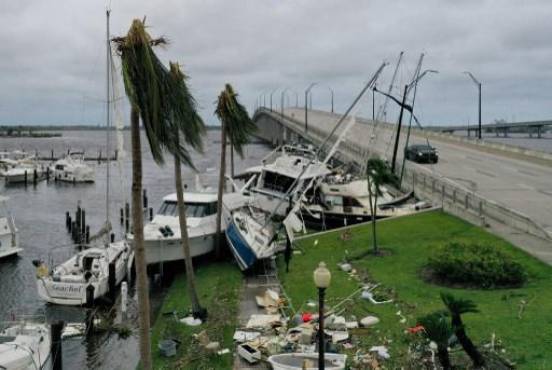FORT MYERS FLORIDA - 29 DE SEPTIEMBRE: Los barcos son empujados hacia arriba en una calzada después de que el huracán Ian pasara por el área el 29 de septiembre de 2022 en Fort Myers, Florida. El huracán trajo fuertes vientos, marejadas ciclónicas y lluvias al área causando daños severos. Joe Raedle/Getty Images/AFP (Foto de JOE RAEDLE/GETTY IMAGES NORTH AMERICA/Getty Images vía AFP)