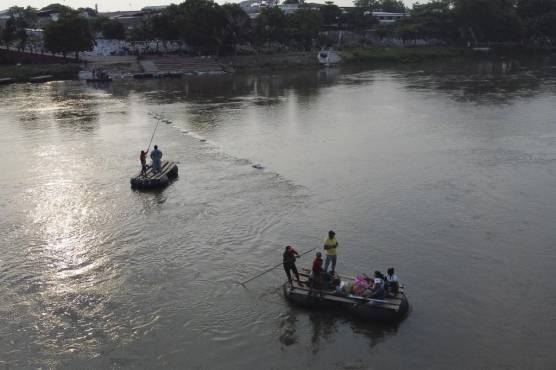 <i>En esta vista aérea, la gente usa balsas improvisadas para cruzar ilegalmente el río Suchiate desde Tecun Uman en Guatemala hasta Ciudad Hidalgo en el estado de Chiapas, México, el 17 de mayo de 2022. (Foto de Stringer / AFP)</i>