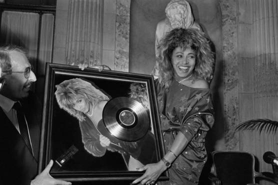 <i>La cantante estadounidense Tina Turner recibe el premio Disco de oro de manos del presidente de Pathé Marconi, Guy Deluz (izquierda), el 8 de octubre de 1986 en París. La cantante que electrizó al público desde la década de 1960 y lanzó discos exitosos durante cinco décadas, murió a la edad de 83 años (Foto de Georges BENDRIHEM / AFP)</i>