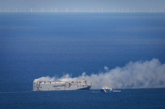 <i>El barco de guardacostas holandés (D) se acerca al buque de carga de transporte de automóviles registrado en Panamá Fremantle Highway en llamas frente a la costa de la isla de Ameland, en el norte de Holanda, el 26 de julio de 2023. (Foto de Jan Spoelstra / ANP / AFP) / Países Bajos FUERA</i>
