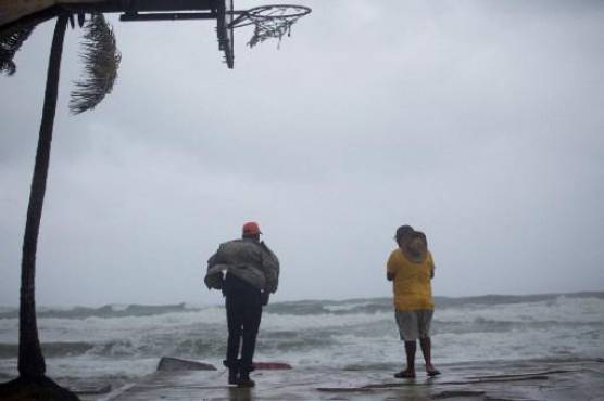 Los hombres miran al mar en la playa de Nagua, República Dominicana, el 19 de septiembre de 2022, durante el paso del huracán Fiona. - El huracán Fiona tocó tierra a lo largo de la costa de la República Dominicana el lunes, dijo el Centro Nacional de Huracanes, luego de que la tormenta arrasara Puerto Rico. (Foto de Erika SANTELICES / AFP)