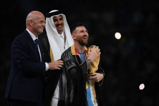 <i>El delantero argentino #10 Lionel Messi sostiene el trofeo de la Copa del Mundo después de recibirlo del presidente de la FIFA Gianni Infantino y el emir Sheikh Tamim bin Hamad al-Thani de Qatar durante la ceremonia del trofeo de la Copa del Mundo de Qatar 2022 después del partido final de fútbol entre Argentina y Francia en el Estadio Lusail en Lusail, al norte de Doha el 18 de diciembre de 2022. - Argentina ganó en la tanda de penaltis. (Foto de FRANCK FIFE / AFP)</i>