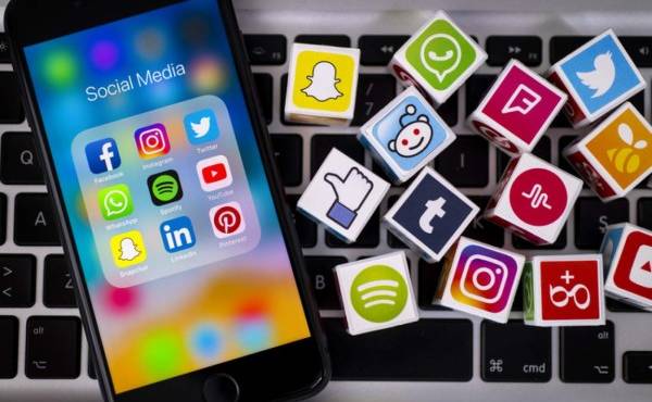 İstanbul, Turkey - May 24, 2018: Plastic cubes with popular social media services icons, including Facebook, Instagram, Youtube, Twitter and an Apple iPhone 8 smart phone on an Apple MacBook Pro keyboard.