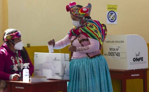 A women wearing a typical quechua attire casts her vote at a polling station in the rural Andean community of Capachica, close to the border with Bolivia, in Peru on June 6, 2021. - Peruvians face a polarising choice between right-wing populist Keiko Fujimori and radical leftist Pedro Castillo when they elect a new president, in a country looking forward for a return to normalcy after years of political turbulence. (Photo by Juan Carlos CISNEROS / AFP)
