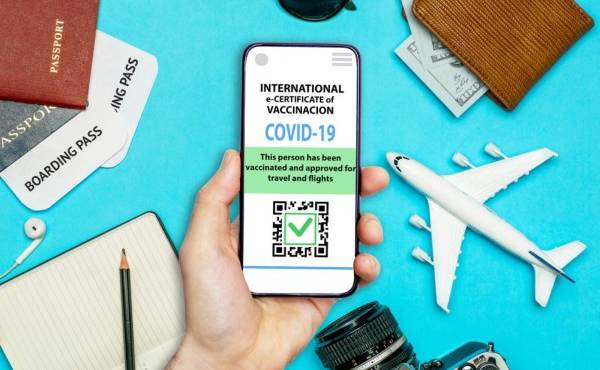 Coronavirus vaccination certificate or vaccine passport for travellers concept. COVID-19 immunity e-passport in the smartphone mobile app for international travelling. Blue background with toy plane