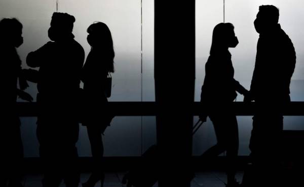 Travelers are pictured in silhouette at Rome's Fiumicino airport on June 3, 2020, as airports and borders reopen for tourists and residents free to travel across the country, within the COVID-19 infection, caused by the novel coronavirus. (Photo by Filippo MONTEFORTE / AFP)