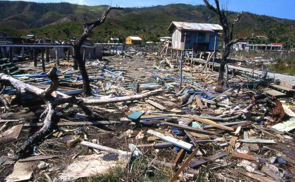 Debris remaining in pond and destruction from 1998 Hurricane Mitch in Savanna Bight village Guanaja Bay Islands Honduras