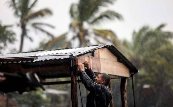 Un hombre protege su casa en Bilwi, Puerto Cabezas, Nicaragua. Eta se mantiene en categoría 4 con vientos de 240km/h y se ubica a poco menos de 40 km al este de la ciudad de Bilwi su velocidad de traslación es de 9km/h. (Photo by INTI OCON / AFP)