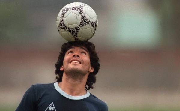 (FILES) In this file picture taken on May 22, 1986 Argentine football star Diego Maradona, wearing a diamond earring, balances a soccer ball on his head as he walks off the practice field following the national team's practice session in Mexico City. - Argentine football legend Diego Maradona turns 60 on October 30, 2020. (Photo by JORGE DURAN / AFP)