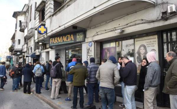 En una farmacia de la Ciudad Vieja de Montevideo, en el centro de la ciudad, compradores hacían fila para adquirir la droga, por primera vez de forma legal. La fila se extendía a la acera.