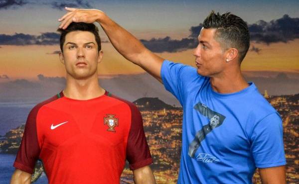 Portugese forward Cristiano Ronaldo poses next to a wax statue representing himself during a visit to the new location of the CR7 museum dedicated his professional career at Funchal, on the Portuguese island of Madeira on July 23, 2016. (Photo by JOANA SOUSA / AFP)