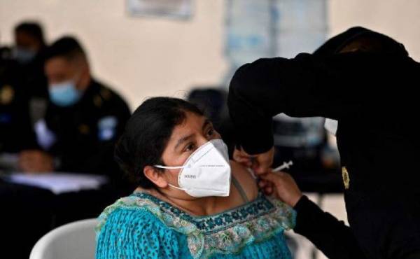 A woman is inoculated with a dose of the AstraZeneca vaccine against COVID-19, at a vaccination center on Constitution Square, in Guatemala City, August 25, 2021, amid a spike in the number of coronavirus cases. (Photo by Johan ORDONEZ / AFP)